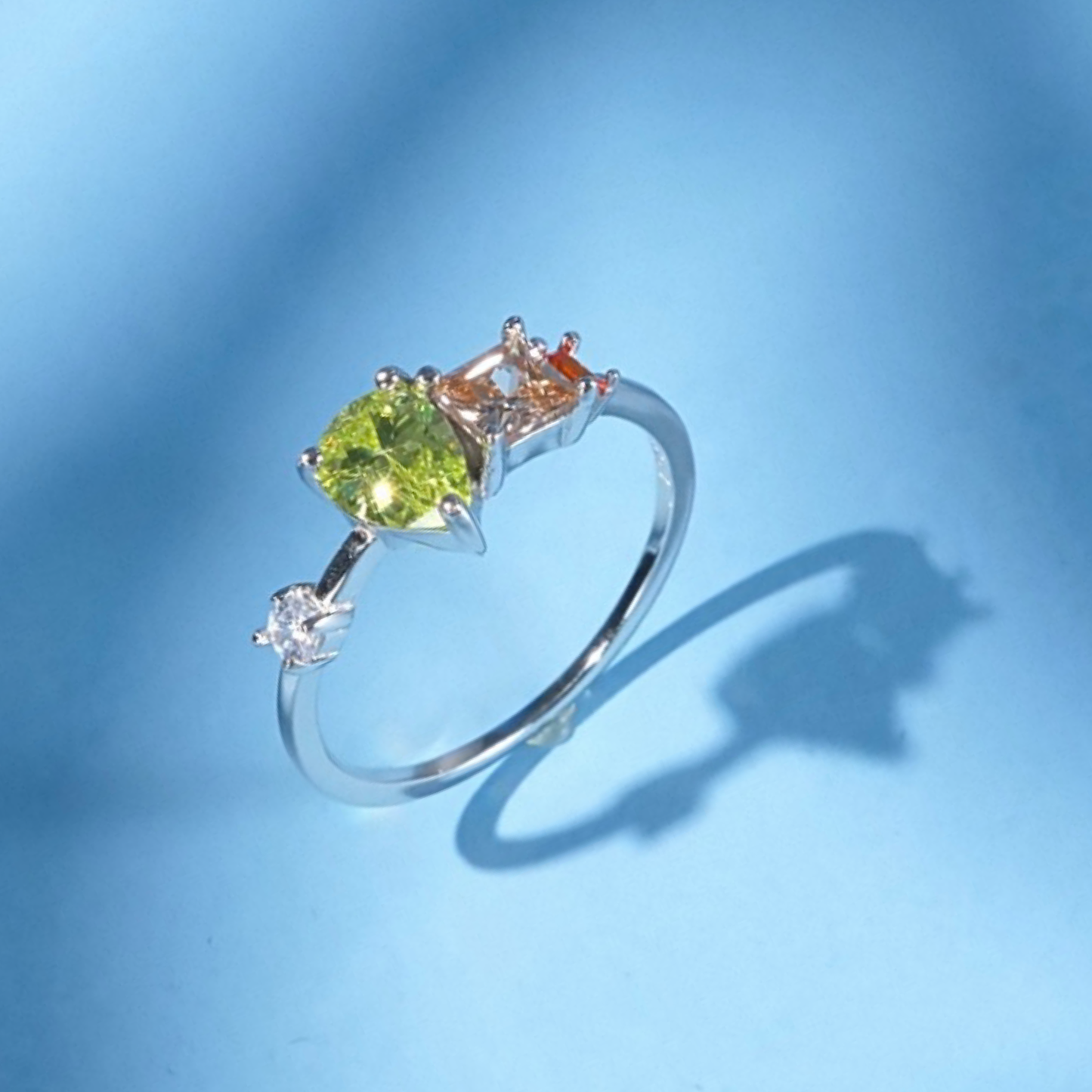 Silver ring with green gemstone on a blue background