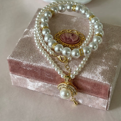 Pearl bracelet with gold accents on a pink jewelry box
