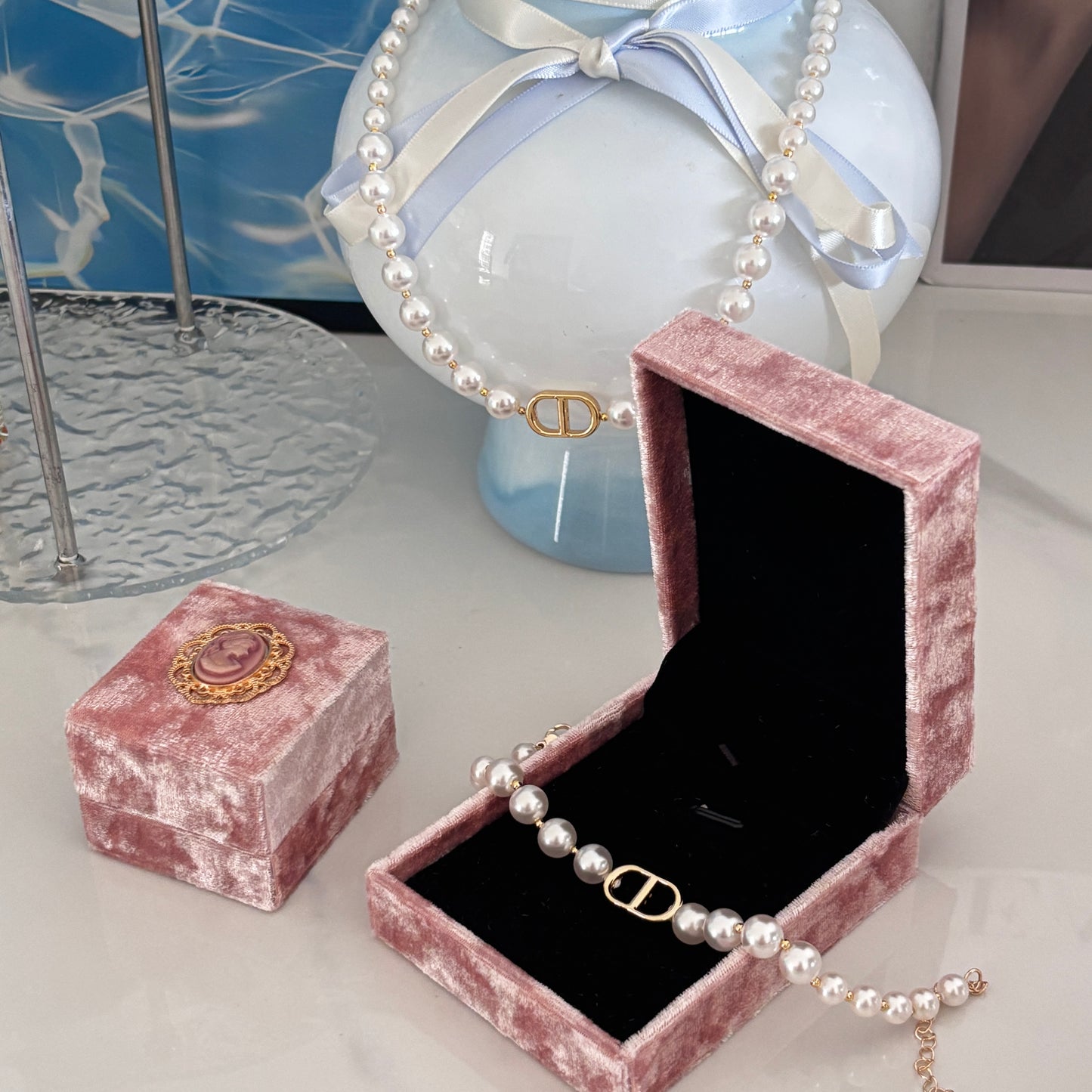 Pink velvet jewelry box with a pearl necklace on a light surface.