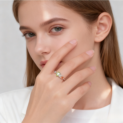 Close-up of a woman wearing a ring with a green gemstone on a plain background