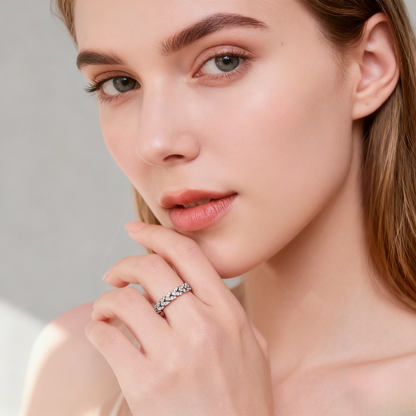 Close-up of a woman wearing a silver ring on a neutral background