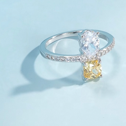 Silver ring with a yellow gemstone on a light blue background