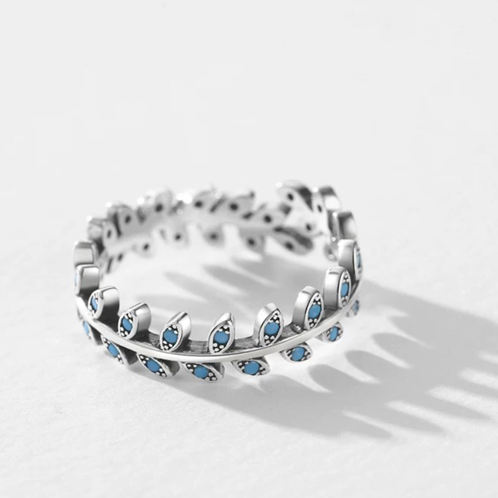 Silver ring with blue gemstones on a white background