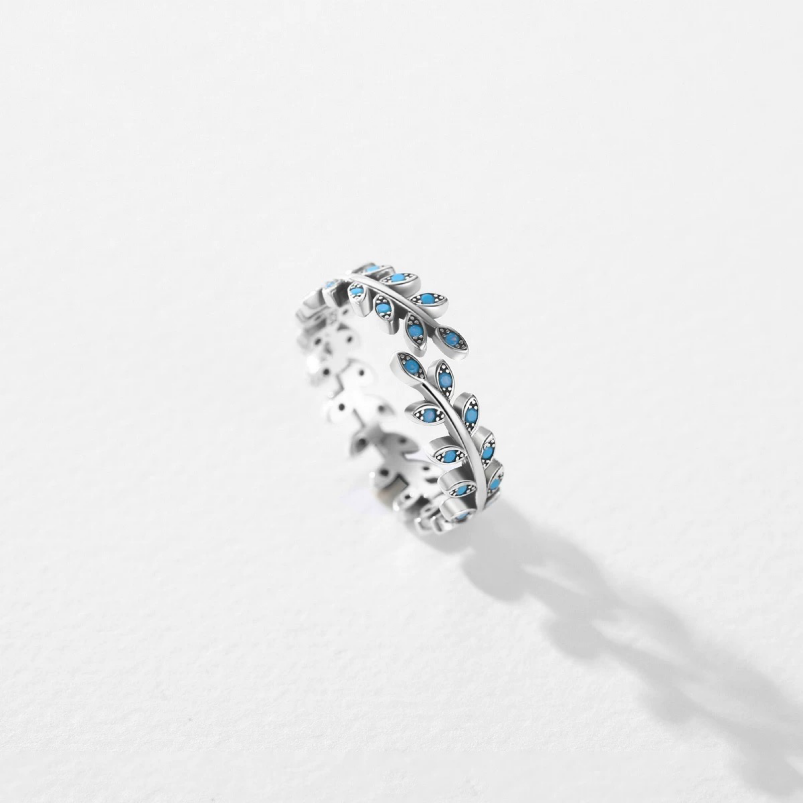 Silver ring with blue gemstones on a white background
