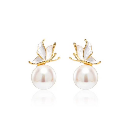 Pearl earrings with gold butterfly accents on a white background
