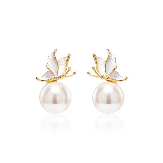 Pearl earrings with gold butterfly accents on a white background