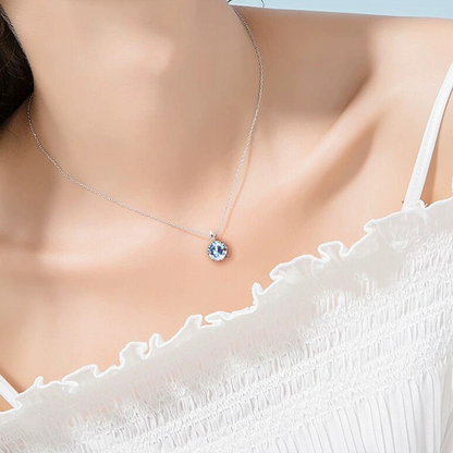 Necklace with a blue pendant on a model wearing a white top