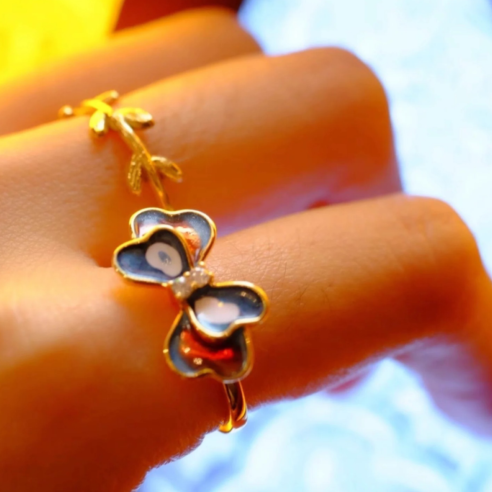 Butterfly-shaped ring on a person's finger with a blurred background