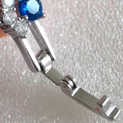 Close-up of a silver bracelet with a blue gemstone on a textured white background