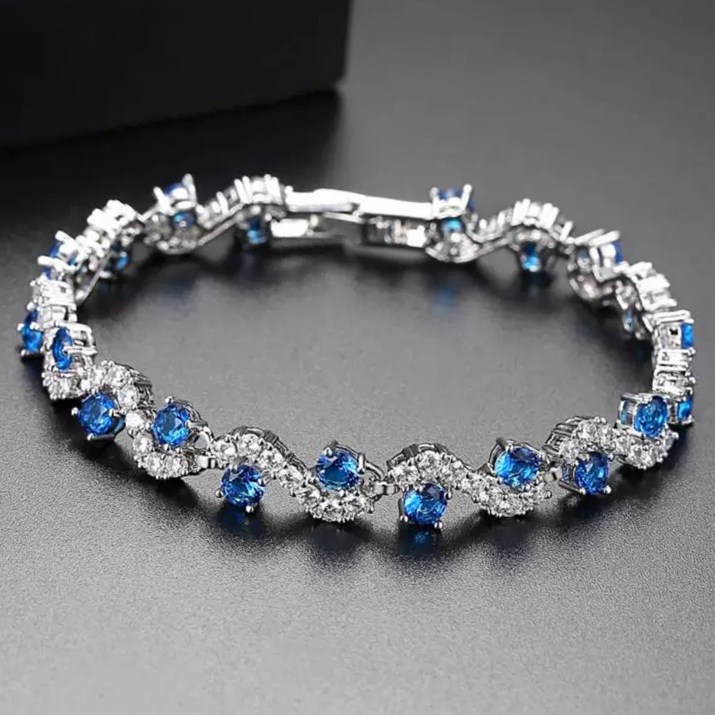 Silver bracelet with blue gemstones on a dark background
