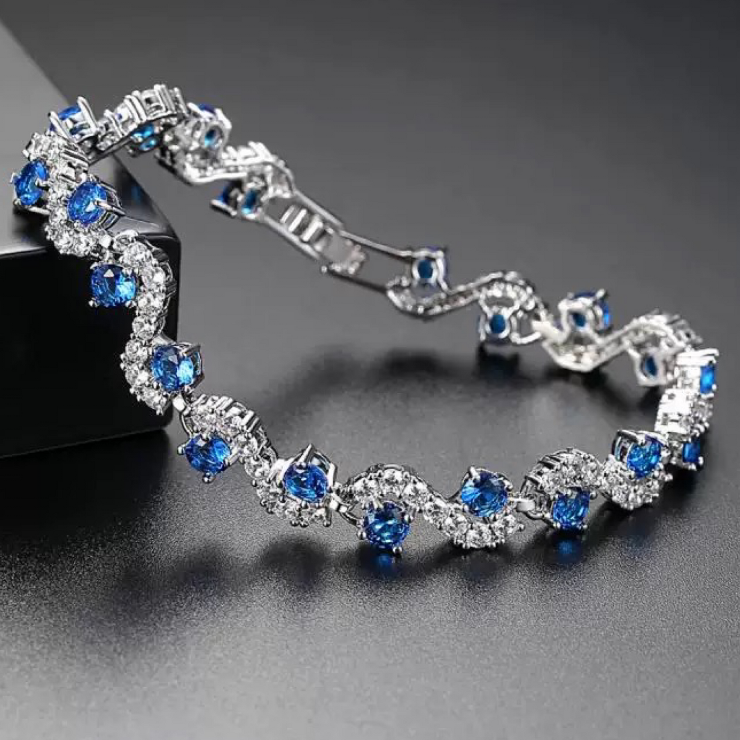 Silver bracelet with blue gemstones on a dark background