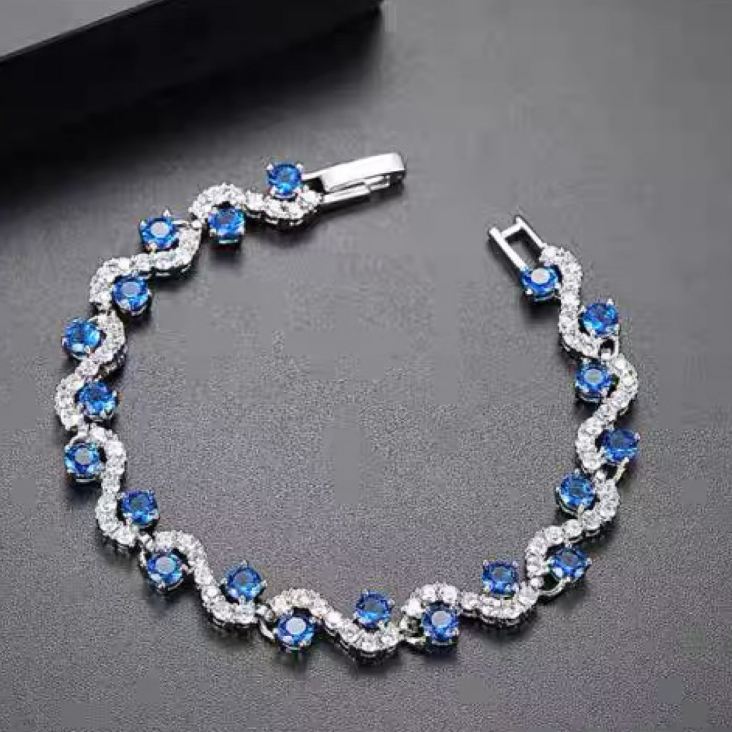 Silver bracelet with blue gemstones on a dark background