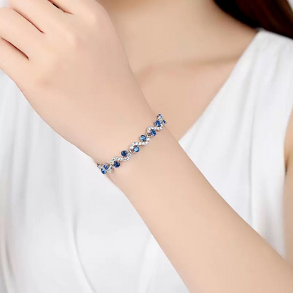 Bracelet with blue stones on a person's wrist against a white background