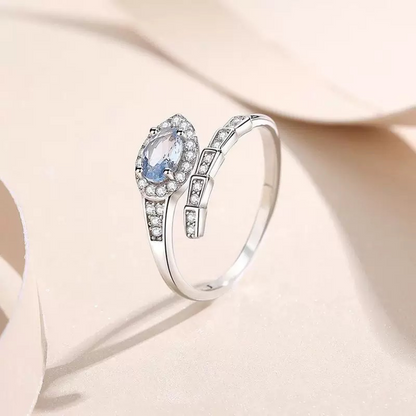 Silver ring with a central gemstone on a soft beige background