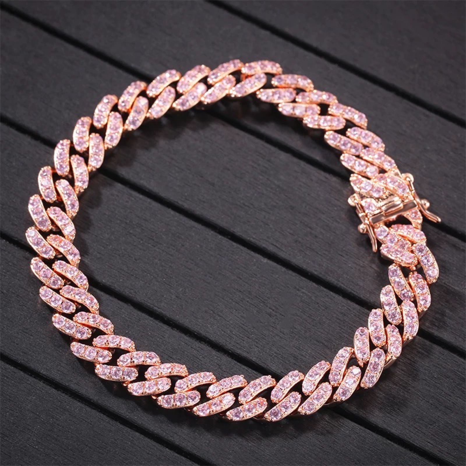 Rose gold chain bracelet on a dark wooden surface