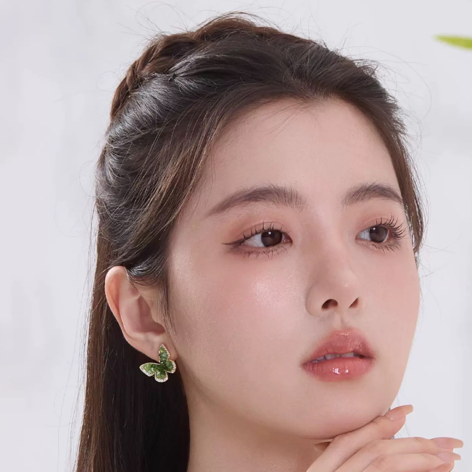 Woman wearing Emerald Green Crystal Butterfly Earrings Clip-On Stud Women Summer 2025 on left ear